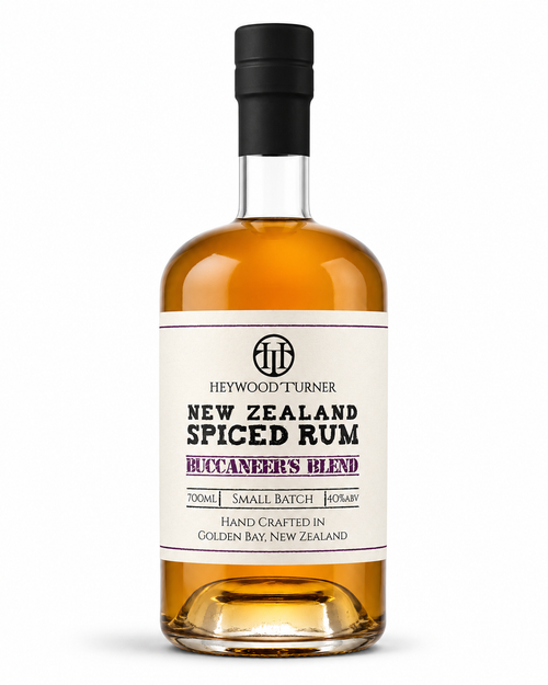 A bottle of Heywood Turner New Zealand Spiced Rum on a clean white background. The bottle is filled with amber-colored rum and features a cream-colored label with black and purple text, sealed with a black cap.